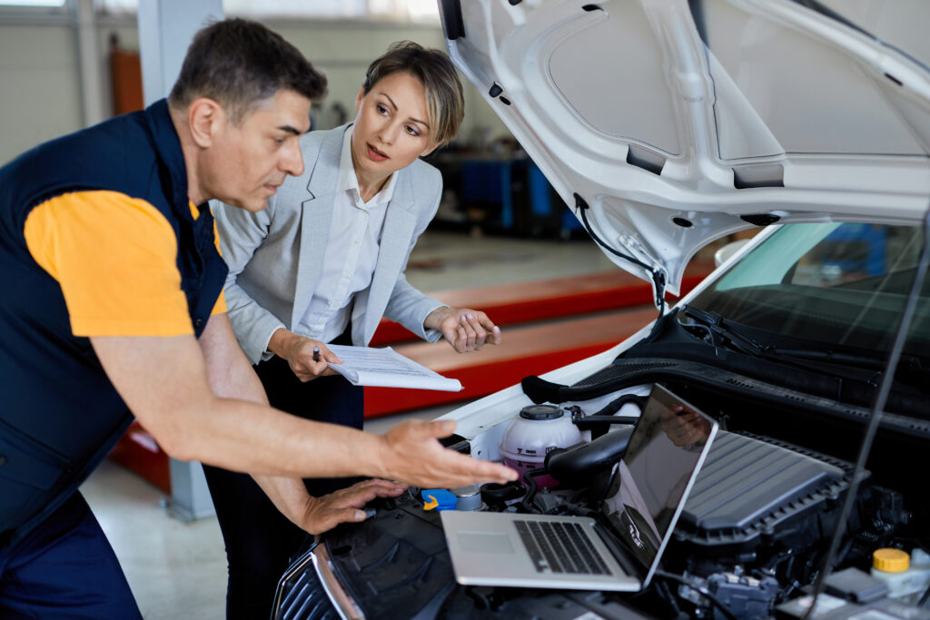 Female manager and car mechanic cooperating while testing